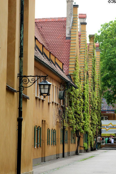 Ivy covered homes with steeply gabled roofs within walls of Fuggerei. Augsburg, Germany.