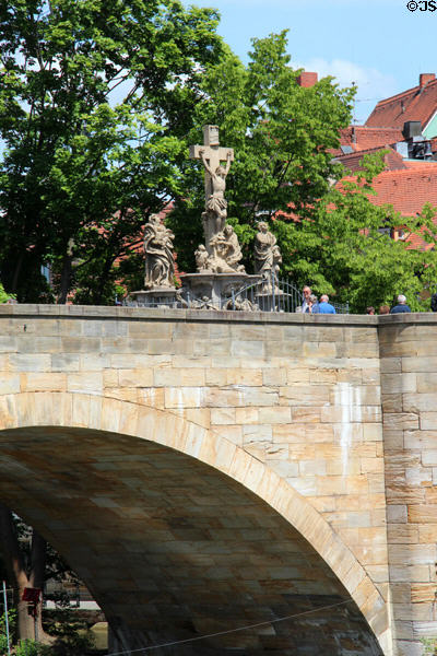 Crucifixion shrine sculpture on arched bridge traversing Bamberg Old Town Hall. Bamberg, Germany.
