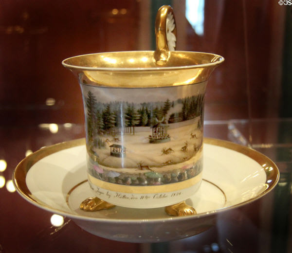Porcelain cup & saucer (1824) with deer hunt from huts scene from Schney b. Lichtenfels, Bavaria at Coburg Castle. Coburg, Germany.