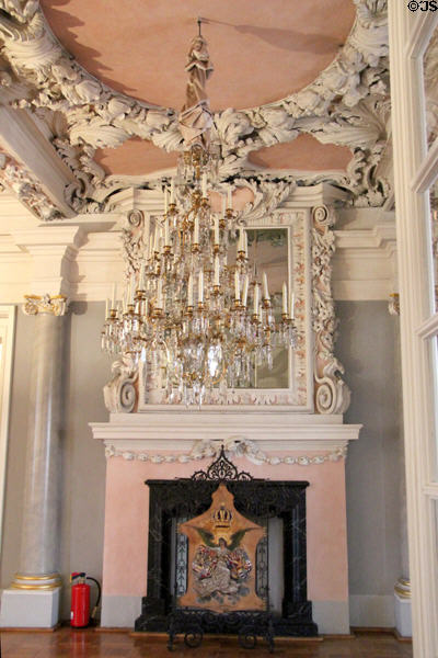 Chandelier & fireplace in Hall of Giants at Ehrenburg Palace. Coburg, Germany.