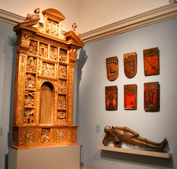 Carved wooden altarpiece (c1650-60) from South Tyrol & painted memorial shields (16thC) depicting symbols of ancestors in Nuremberg churches at Germanisches Nationalmuseum. Nuremberg, Germany.
