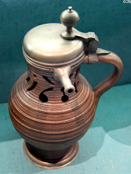 Earthenware puzzle jug with pewter mount (1681) from Hesse at Germanisches Nationalmuseum. Nuremberg, Germany.