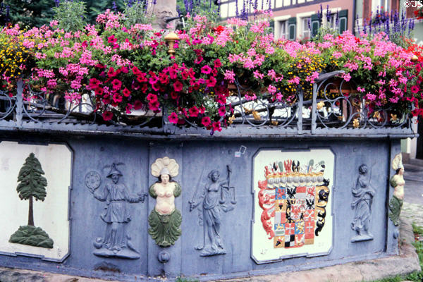Cascading flowers & wall with ornamental carvings in historic center. Nördlingen, Germany.
