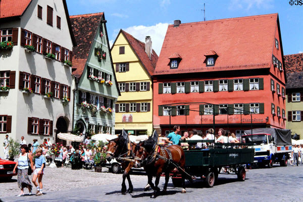 Wagon & pair of horses carrying visitors through historic center. Dinkelsbühl, Germany.