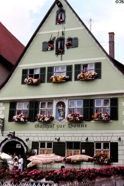 Gasthof zur Sonne, traditional Bavarian style building with facade inset holding statue of Madonna & Child in historic center. Dinkelsbühl, Germany.