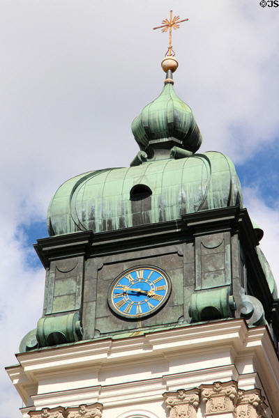 Cross with golden sunburst atop clock tower at Ettal Benedictine Abbey. Ettal village, Germany.