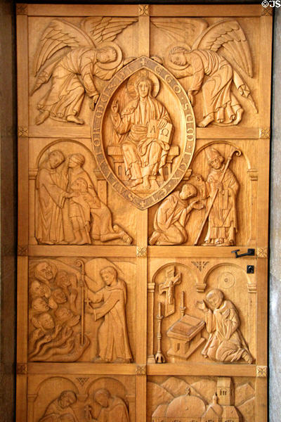 Wooden door carved in German style with scenes of the life of St Mang at Basilica St Mang. Füssen, Germany.