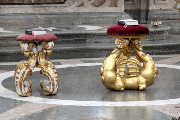 Stools supported by ornate carvings, one baroque & one dragon, at Basilica St Mang. Füssen, Germany.