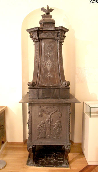 Ceramic & cast iron heating stove (1733) with scene of Christ's crucifixion with Mary & John at foot of cross at museum of Kloster Wiblingen. Ulm, Germany.