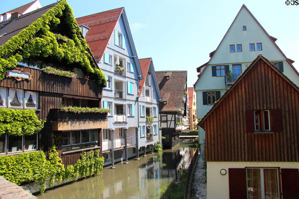 Blau River lined by steep roofed homes in historic style. Ulm, Germany.