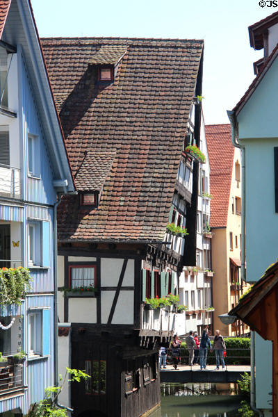 Pedestrian crossing between homes over narrow Blau River. Ulm, Germany.