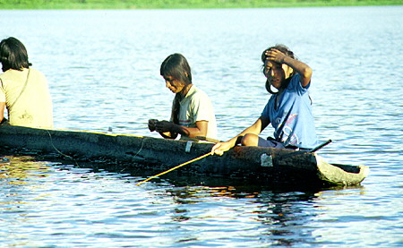 Natives fishing from canoe in Lake Limoncocha. Ecuador.