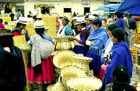 Native women sell baskets in the market in Cuenca. Ecuador.