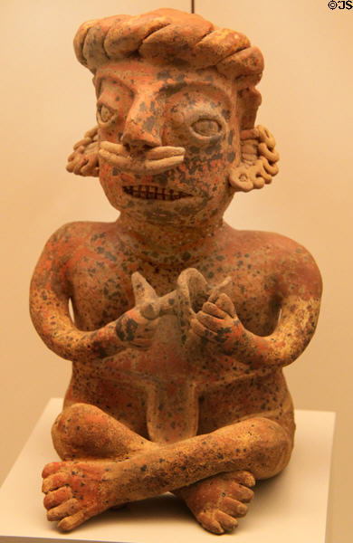 Colima culture ceramic sitting male figure holding fish (400 BCE - 100 CE) from Western Mexico at Museum of America. Madrid, Spain.