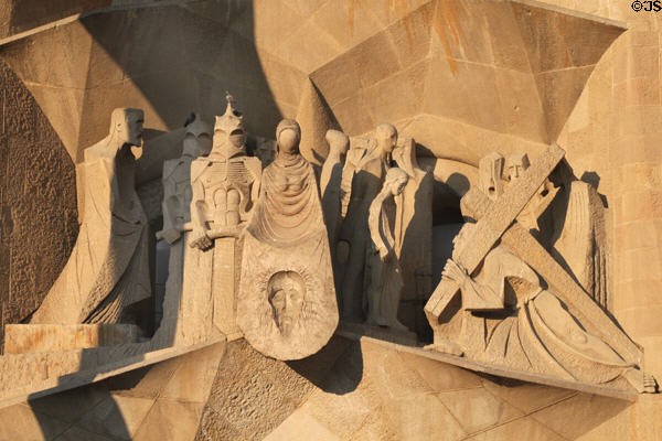 Christ carrying cross past Roman soldiers & Veronica holding cloth with image of face on Passion Facade at Sagrada Familia. Barcelona, Spain.