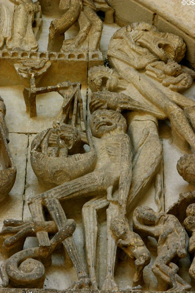 Detail of Satan pressing on balance beam to send extra soles to Hell at Last Judgment on tympanum of Cathedral St Lazarre. Autun, France.