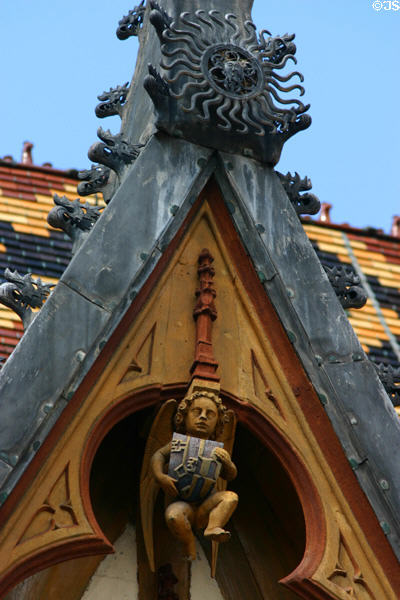 Ironwork detail of gable with carved cherub holding coat of arms in courtyard of Hotel Dieu. Beaune, France.