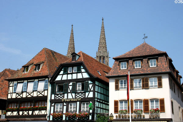 Half-timbered buildings with towers of Sts Peter & Paul church. Obernai, France.