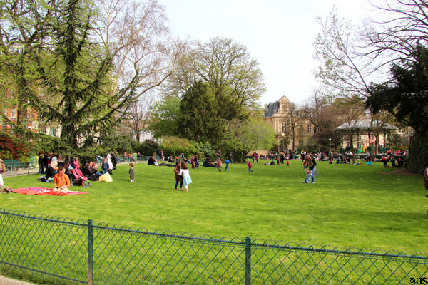 People on lawn in Square du Temple park. Paris, France.