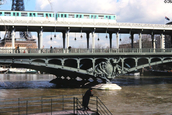 Metro train crosses upper level of Pont de Bir-Hakeim (former Pont de Passy) pedestrian bridge near Eiffel Tower. Paris, France.