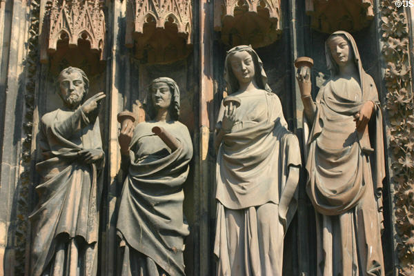 Wise virgins holding their lamps upright at left door of Cathedral. Strasbourg, France.