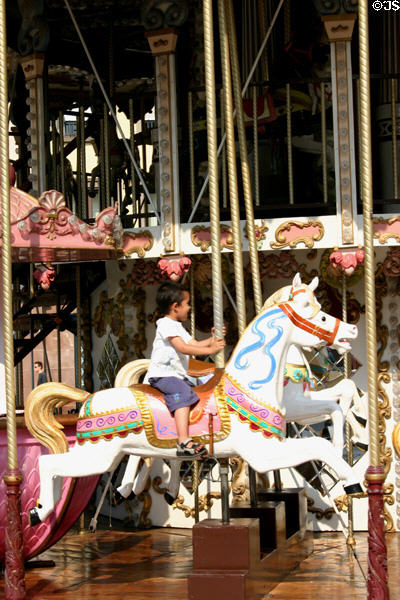 Horse & young rider on carousel in Place Guttenberg. Strasbourg, France.