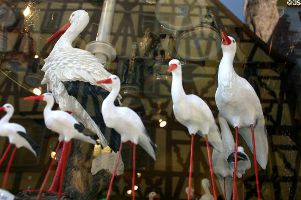 Plastic storks in shop window in Alsace. France.