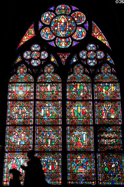 Virgin circled by musical angels over Medieval worship scenes stained glass window in Notre Dame Cathedral. Paris, France.