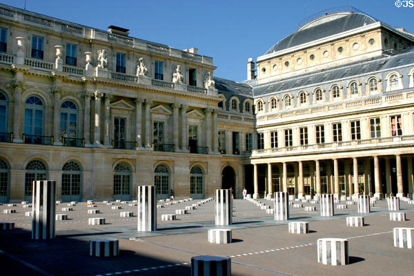 Daniel Buren's Columns art installation (c1985) in Grand court at Palais Royale with row of round windows of Comedie Français theater at top right. Paris, France.