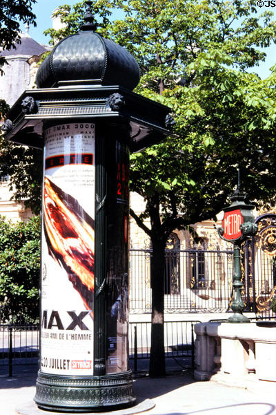 Cylindrical advertising column (street furniture named Morris column) has evolved on streets of Paris since c1870 on Champs Elysees. Paris, France.