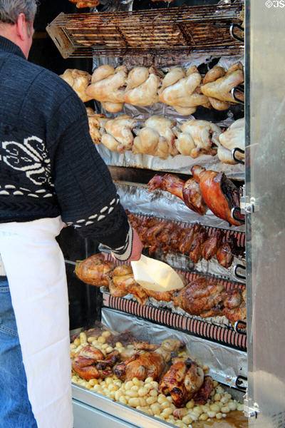 Shop with racks of roasted chickens & meats. Paris, France.