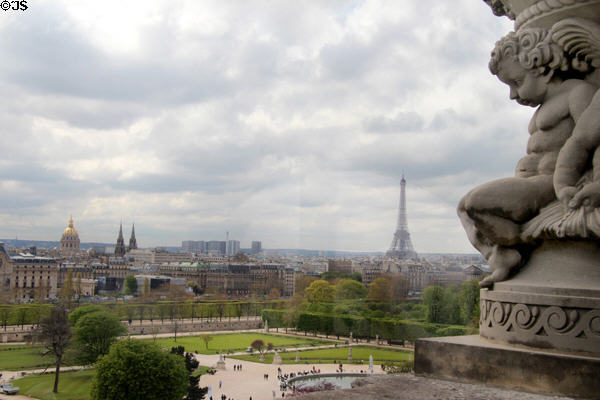 Tuileries gardens with Les Invalides & Eiffel Tower beyond flanked by sculpted cherub of Louvre Palace. Paris, France.