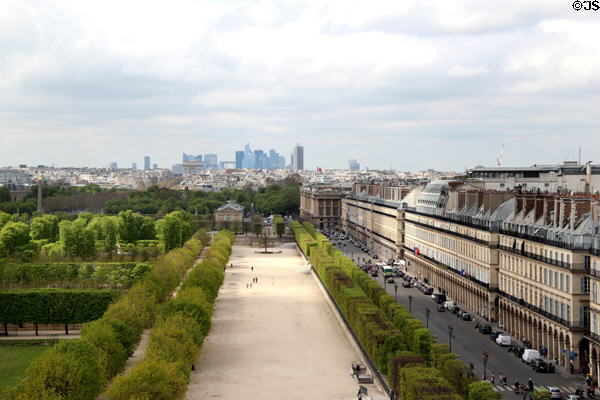 Tuileries gardens bordered by rue de Rivoli with highrises of La Defense beyond seen from Louvre Palace. Paris, France.