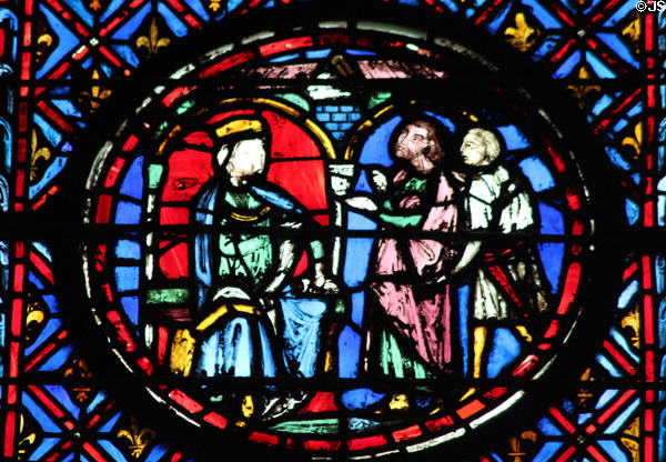 Seated king with men holding chalice stained glass scene at St Chapelle. Paris, France.
