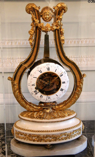Lyre shaped clock (c1785) with gilded bronze, white marble, enamel & glass by Charles Bertrand at Carnavalet Museum. Paris, France.