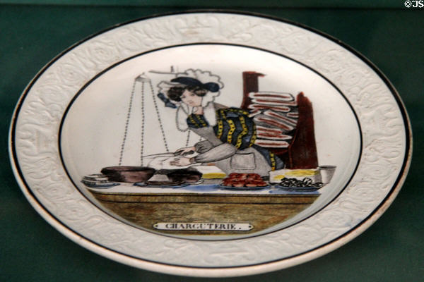 The Butcher Shop (c1830) one of a set of plates decorated with food shopping scenes, Choisy-le-Roi fine earthenware made by Valentin Paillart & Hippolyte Hautin at Carnavalet Museum. Paris, France.