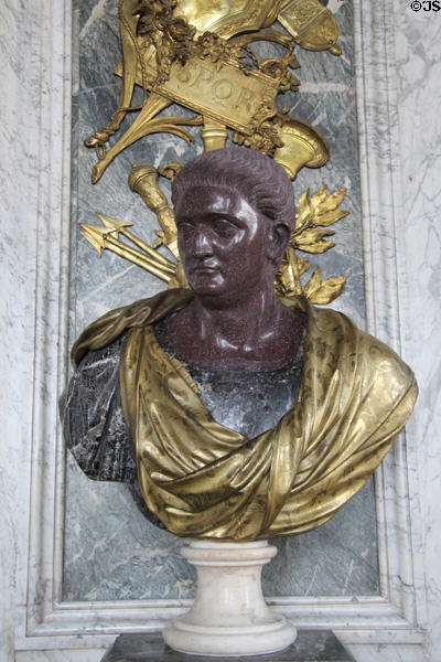 Porphyry stone bust of roman emperor with golden toga at Versailles Palace. Versailles, France.