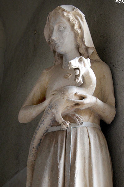 Eve statue (c1230) carrying a serpent, similar to a dragon, with an apple between its teeth removed from north facade of Reims Cathedral at Tau Palace Museum on website. Reims, France.