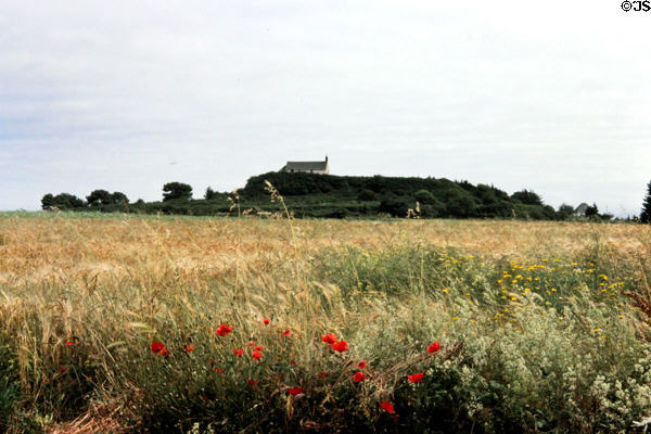 Meadow with chapel of Saint-Michel Tumulus in distance. Carnac, France.