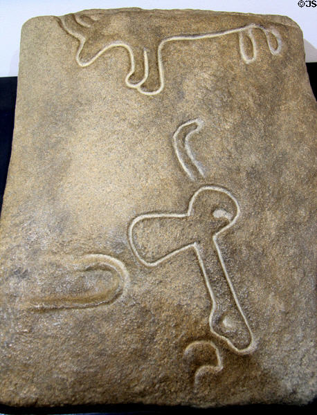 Bovine, axe & shepard's crook/crosier symbols on dolmen slab displayed at Locmariaquer Megalithic site. Locmariaquer, France.