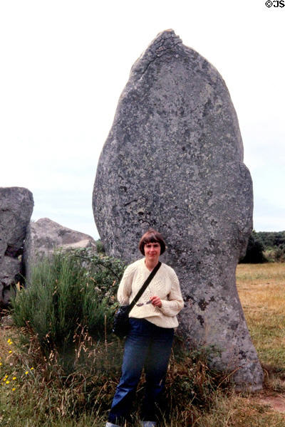 Visitor in front of megalith. Carnac, France.