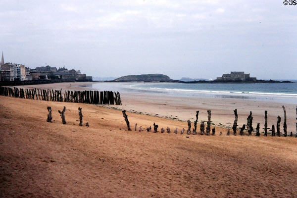Empty beach with anti-erosion fences & islands in distance. St Malo, France.