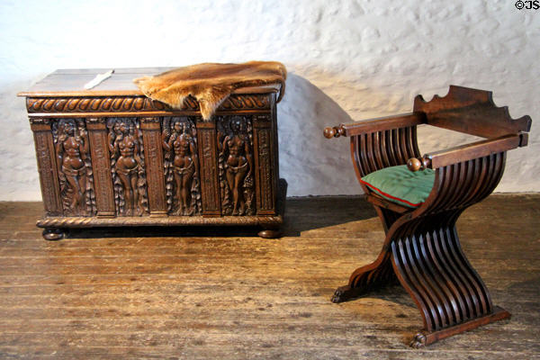 Ornate carved chest & X-shaped antique-inspired wooden chair which can be folded & carried at Jacques Cartier Manor House Museum. St Malo, France.