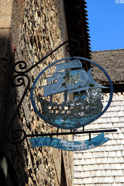 Old metal sign with a sailing ship advertising hotel along Grande Rue. Mont-St-Michel, France.