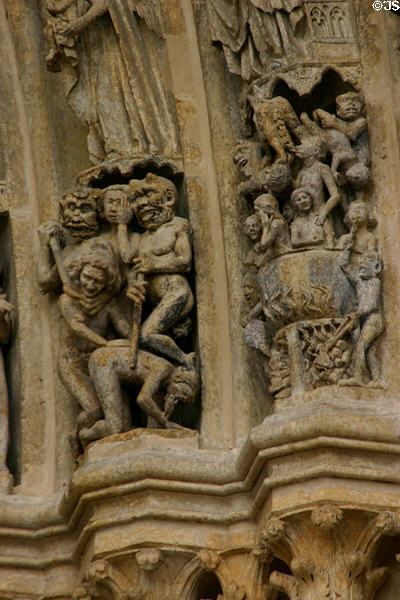 Souls tortured & boiled over fires of hell on Last Judgment carving of Amiens Cathedral. Amiens, France.