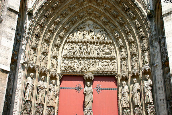 Gothic arch with crucifixion carving surrounded by saints over western portal of Rouen Cathedral. Rouen, France.
