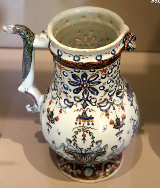 Rouen-made earthenware puzzle jug painted blue & red (c1725) at Rouen Ceramic Museum. Rouen, France.