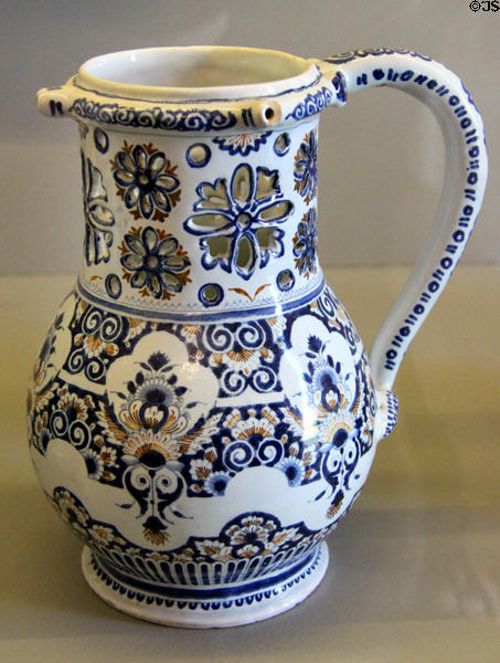 Rouen-made earthenware puzzle jug painted blue & red (c1720) at Rouen Ceramic Museum. Rouen, France.