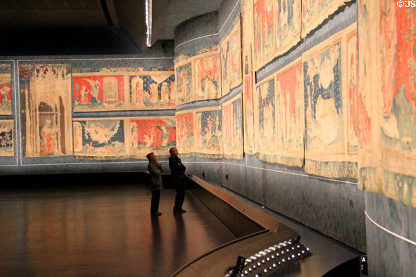 Visitors studying Apocalypse Tapestry at Angers Chateau. Angers, France.