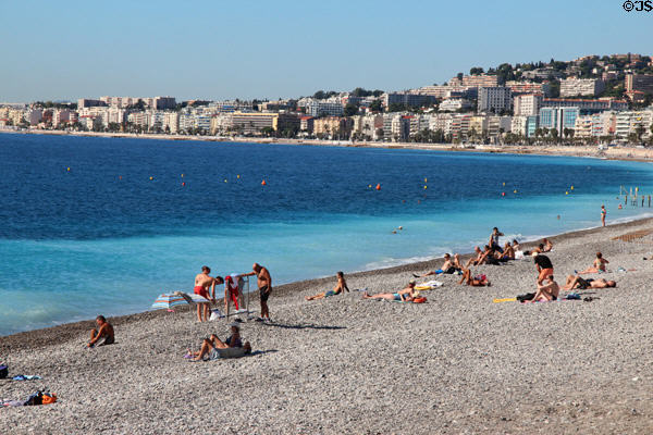 Sunbathers on beach facing Bay of Angers along Promenade des Anglais. Nice, France.
